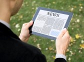 11225125-businessman-reading-news-on-digital-tablet-at-park